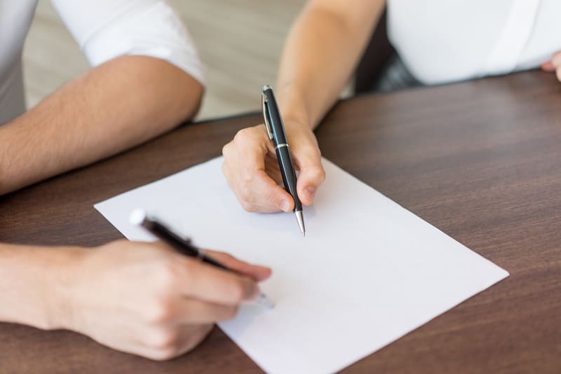 Pareja firmando el convenio regulador de su divorcio express en un despacho de abogados en Pontevedra